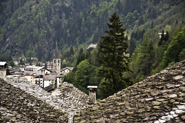 Grüne Gebirgslandschaft mit den alten Häusern im Vordergrund