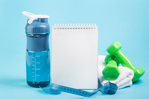 Grüne Gewichte und Kopierraum Notizblock-Wasserkonzept