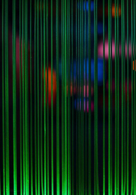 Grüne Lichtlinien und farbige Flecken von Glasfaserkabeln, Computerkommunikationsidee, selektiver Fokus, Unschärfe, dunkler Hintergrund, vertikaler Rahmen