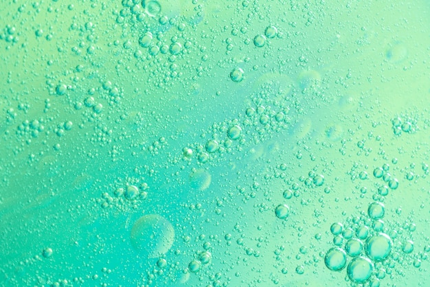 Grüne luftige Wasserblasen und glühende Tropfen