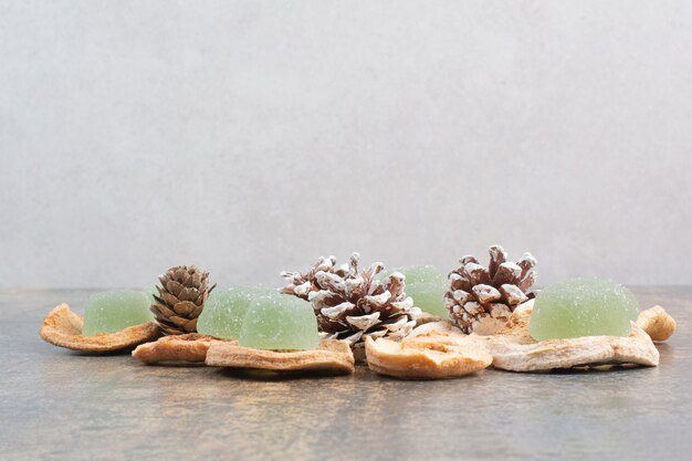 Grüne Marmelade mit getrockneten Früchten und Tannenzapfen auf Marmorhintergrund. Hochwertiges Foto