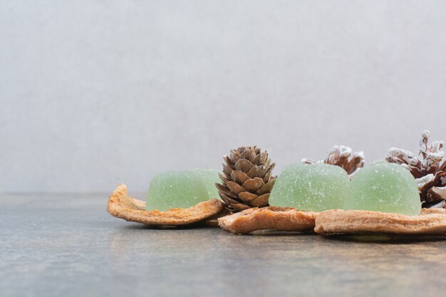 Grüne Marmelade mit getrockneten Früchten und Tannenzapfen auf Marmorhintergrund. Hochwertiges Foto