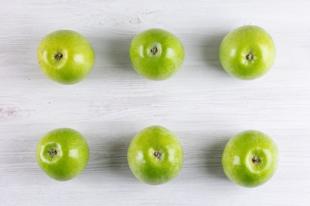 Grüne Äpfel der Draufsicht auf weißer hölzerner Horizontaler