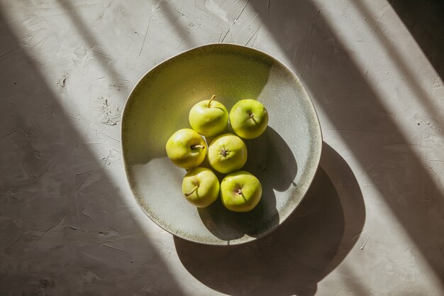 Grüne Äpfel der Draufsicht in Platte auf strukturiertem Tisch. horizontal