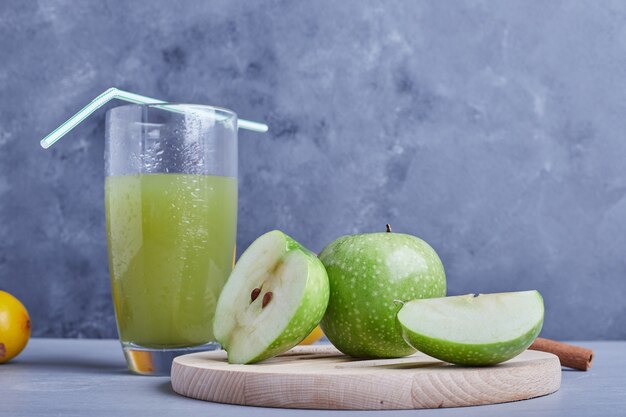 Grüne Äpfel mit einem Glas Saft.