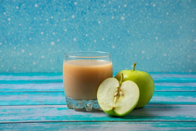 Grüne Äpfel mit einer Tasse Saft auf dem Tisch