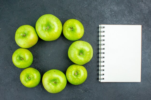 Grüne Äpfel Notizbuch der Draufsichtkreisreihe auf dunklem Tisch