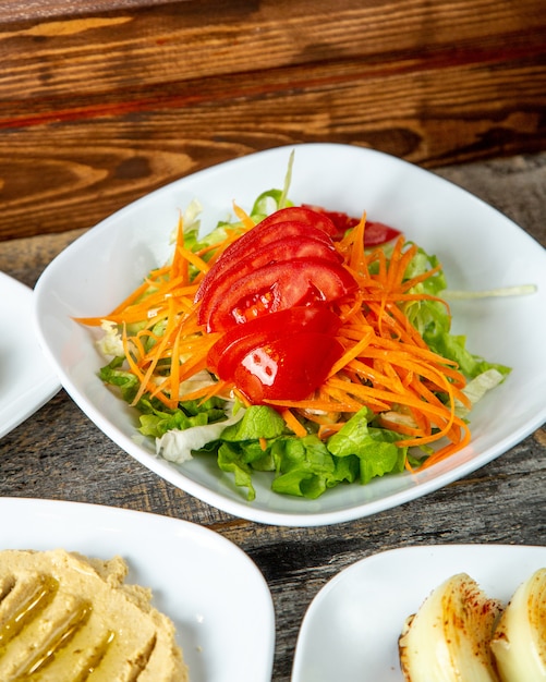 Grüne Salatsalat-Tomaten-Karotten-Seitenansicht