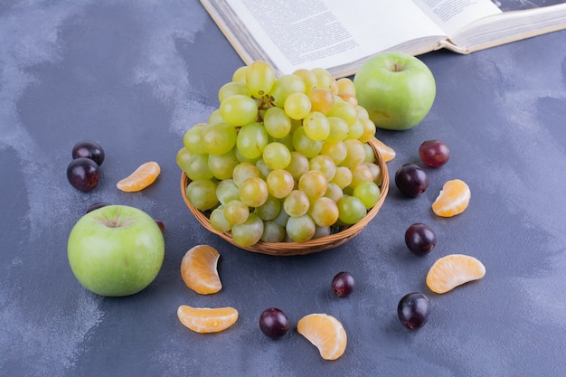 Grüne Trauben mit Apfel, Mandarine und Kirschen.