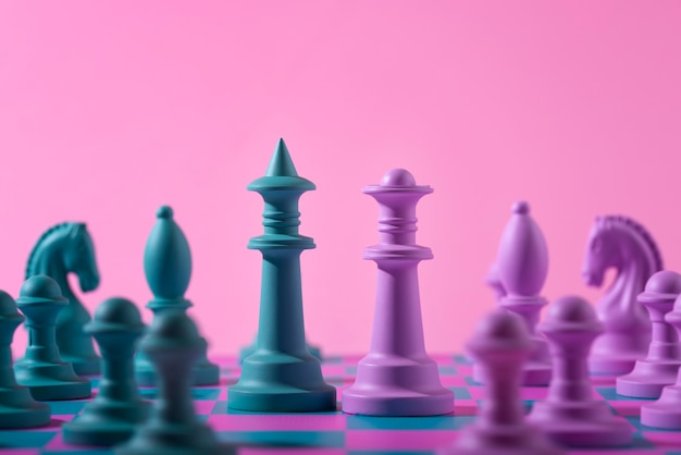 Kostenloses Foto grüne und rosa schachfiguren mit spielbrett