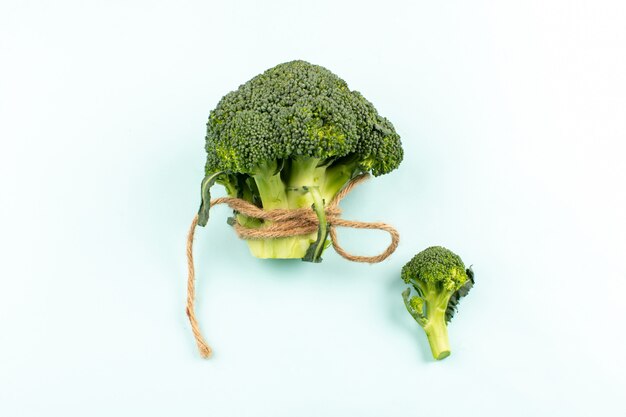 grüner Brokkoli der Draufsicht lokalisiert auf dem weißen Schreibtisch