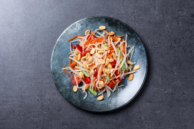 Grüner Papaya-Salat som tam thai auf schwarzem Schiefergrund