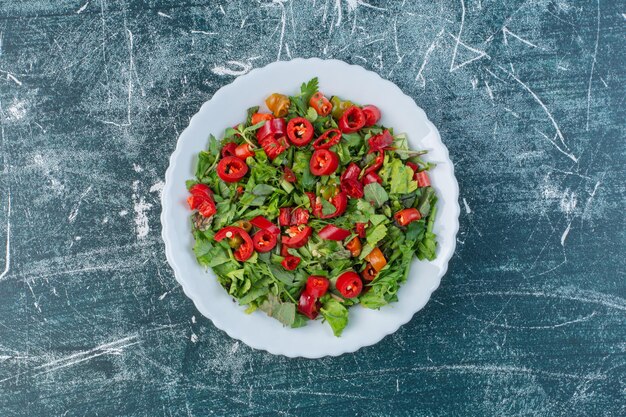 Grüner Salat mit gehackten roten Chilischoten.