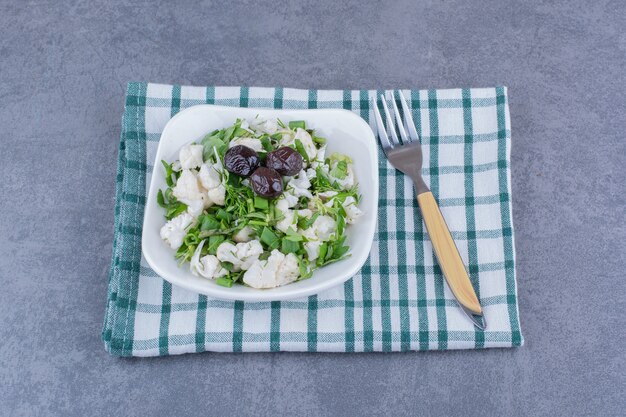 Grüner Salat mit Kräutern und Blumenkohl in einer Keramikschale