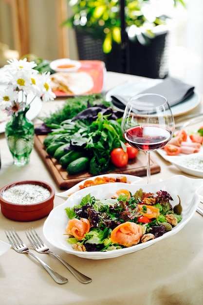 Grüner salat mit kräutern und einem glas rotwein.