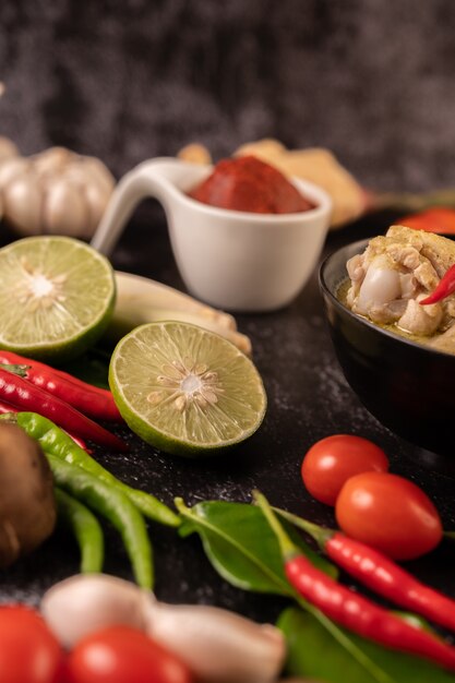 Grünes Curry aus Hühnchen, Chili und Basilikum mit Tomaten, Kaffirlimettenblättern und Knoblauch. Fokus Limette