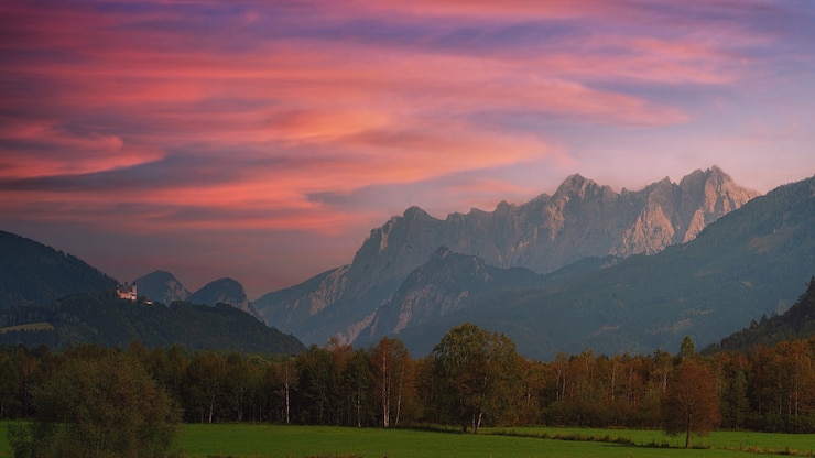 Kostenlose Foto grünes grasfeld nahe berg unter bewölktem himmel während des tages