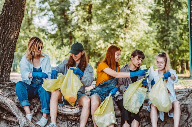 Kostenloses Foto gruppe aktivistenfreunde, die plastikabfall am park sammeln. umweltschutz.