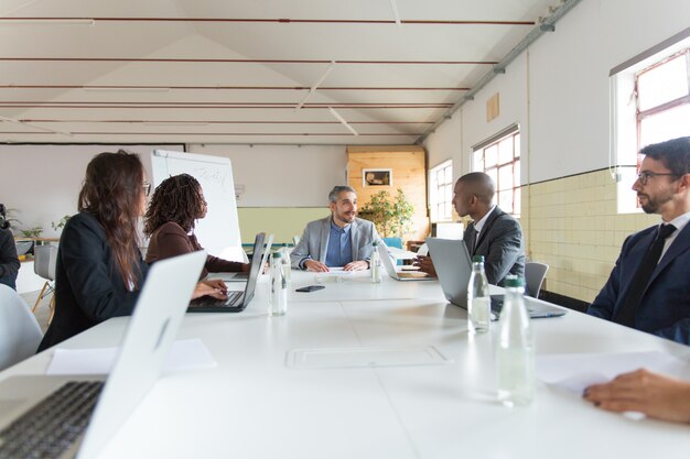 Gruppe beschäftigter Manager während der Morgenanweisung