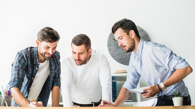 Kostenloses Foto gruppe des jungen männlichen architekten, der im büro arbeitet