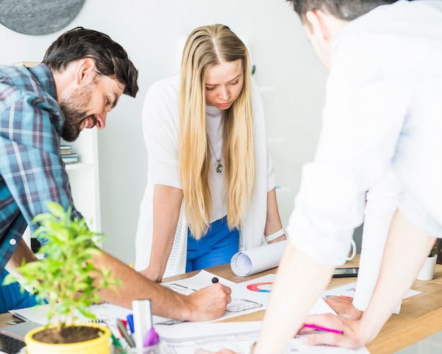 Gruppe des jungen männlichen und weiblichen Architekten, der im Büro arbeitet