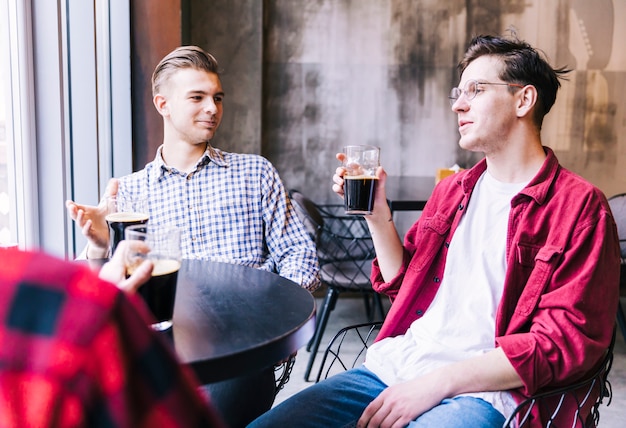 Gruppe des männlichen Freundes das Bier im Restaurant genießend