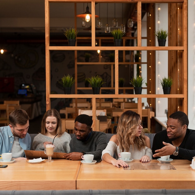 Kostenloses Foto gruppe freunde, die am restaurant sich treffen