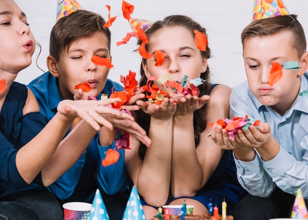 Gruppe Freunde, die Konfetti am Geburtstag durchbrennen