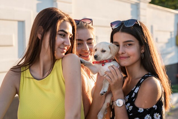 Gruppe Freunde, die mit nettem Hund aufwerfen