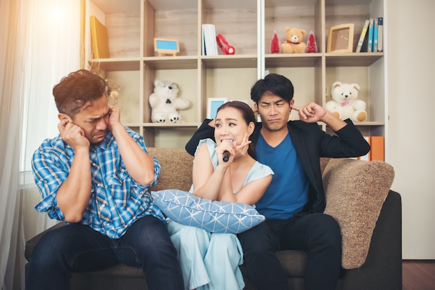 Gruppe Freunde, die Spaß am Wohnzimmer zusammen ein Lied singen haben