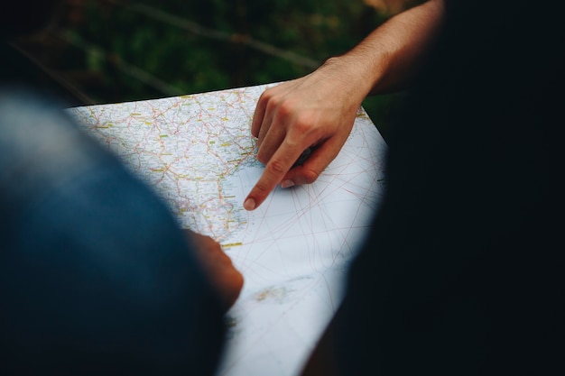 Gruppe Freunde, die zusammen ein Reise- und Teamwork-Konzept der Karte betrachten