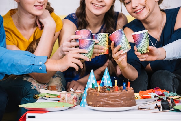 Gruppe Freunde, welche die Gläser Saft auf der Geburtstagsfeier rösten