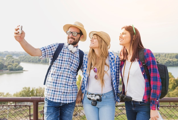 Gruppe glückliche Freunde, die selfie auf Mobiltelefon an draußen nehmen