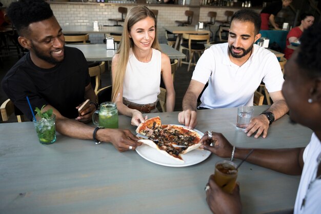 Gruppe glückliche Leute, die Pizza essen