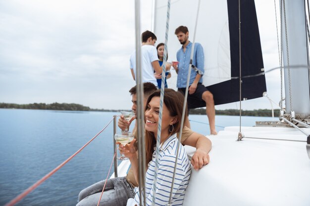 Gruppe glücklicher Freunde, die Wodka-Cocktails auf der Bootsparty im Freien trinken, Sommer