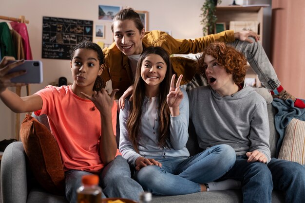 Gruppe jugendlicher Freunde, die zu Hause zusammen Selfie machen