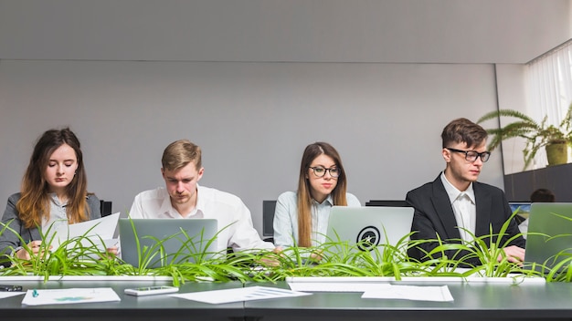 Gruppe junge Wirtschaftler, die an Laptop im Büro arbeiten