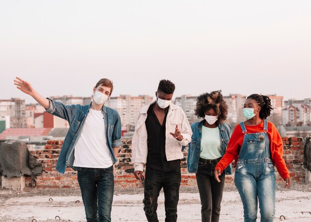 Gruppe junger Leute, die mit chirurgischen Masken heraushängen