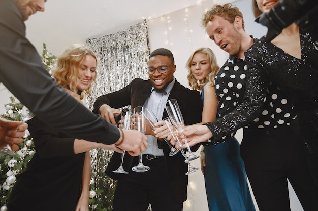 Gruppe junger Leute, die neues Jahr feiern. Freunde trinken Champagner.