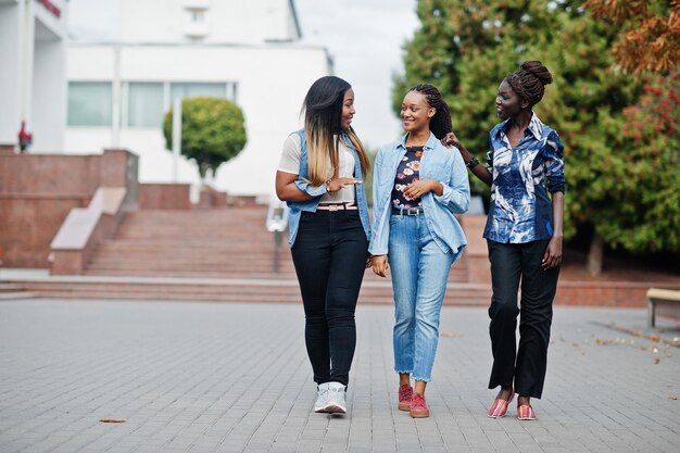 Gruppe junger schwarzer Freundinnen, die in der Stadt herumhängen Multirassische afrikanische Frauen, die auf der Straße spazieren und diskutieren