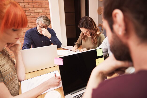 Gruppe kreativer Menschen, die das Ergebnis der Arbeit analysieren