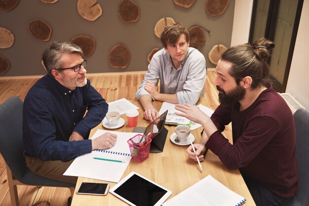 Gruppe kreativer Menschen, die das Ergebnis der Arbeit analysieren