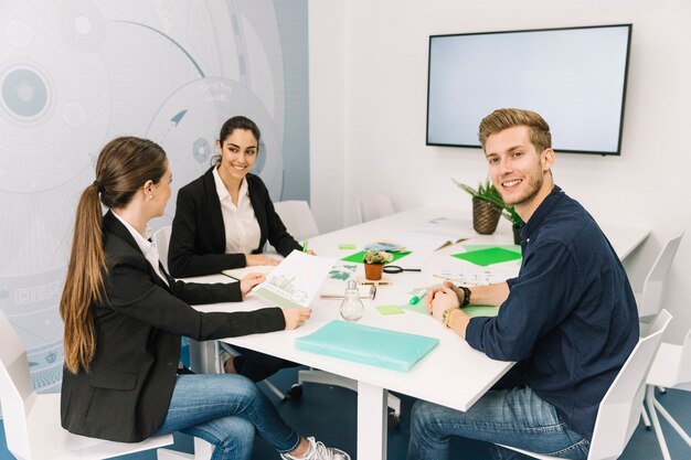 Gruppe lächelnde junge Wirtschaftler am Arbeitsplatz