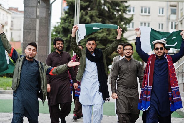 Gruppe pakistanischer Männer, die traditionelle Kleidung Salwar Kameez oder Kurta mit pakistanischen Flaggen tragen