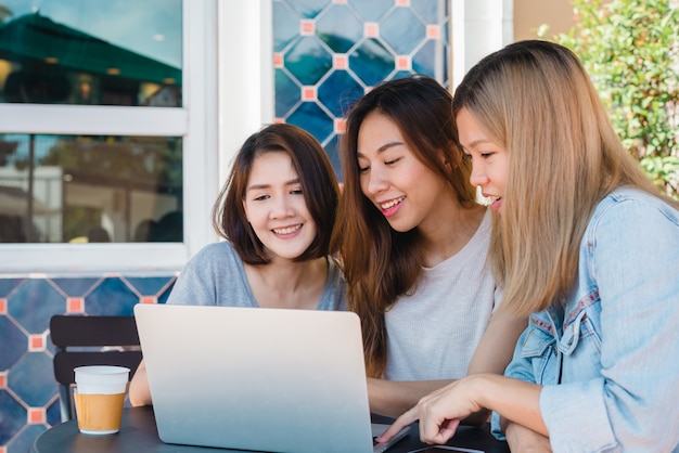 Gruppe schöne freiberufliche asiatische Frauen des intelligenten Geschäfts in der intelligenten Freizeitkleidung, die zusammen an Schoss arbeitet