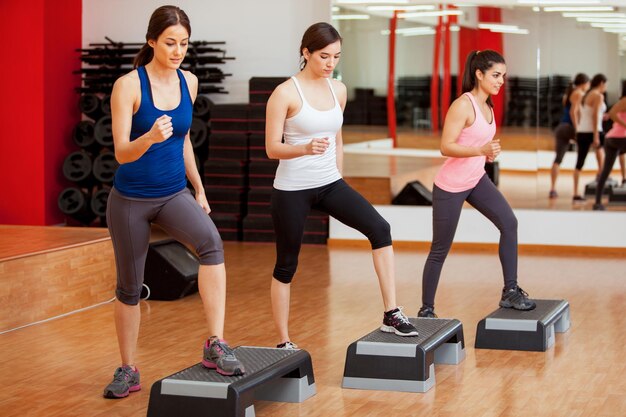 Gruppe süßer Frauen, die trainieren und Step-Aerobic machen