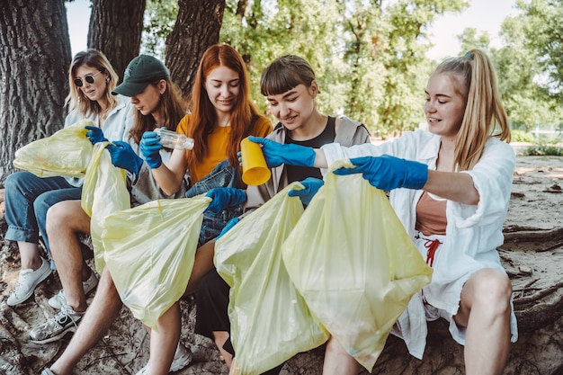 Gruppe von Aktivistenfreunden, die Plastikmüll im Park sammeln. Umweltschutz.