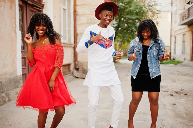 Gruppe von drei stilvollen, trendigen Afro-Frankreich-Freunden posierte am Herbsttag Schwarzafrikanisches Mannmodell mit zwei dunkelhäutigen Frauen