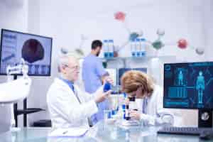 Kostenloses Foto gruppe von forschern in der pharmakologie in einem krankenhauslabor. moderne ausrüstung im forschungslabor.