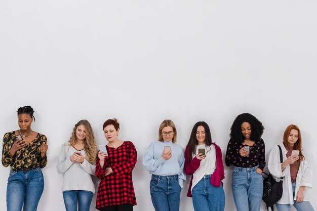 Gruppe von Frauen, die auf ihren Handys schauen